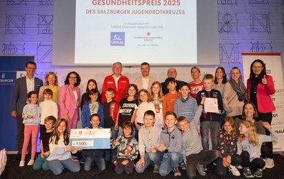 Schülerinnen der Volksschule Bergheim mit Ehrengästen auf der Bühne im SN-Saal.