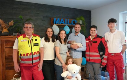 Baby Mailo mit seinen Eltern, seiner Großmutter und Rettungssanitäterinnen des Roten Kreuzes.