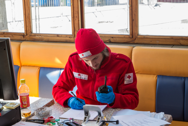 Ein Zivildiener schreibt und hält ein Funkgerät in der Hand