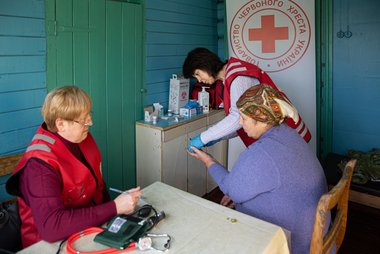 Rotkreuz Mitarbeiterinnen und ältere Dame in der Ukraine