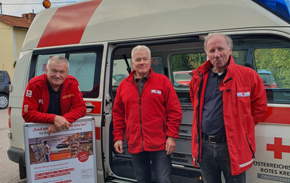 3 freiwillige Rotkreuz-Markt-Fahrer vor dem Transportfahrzeug