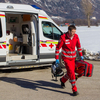 Ein Rotkreuz Sanitäter kommt am Unfallort an. In seiner Hand befindet sich ein Notfallrucksack