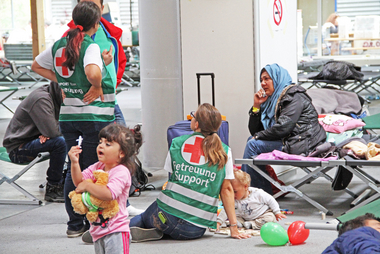 Rot-Kreuz-Mitarbeiterinnen kümmern sich um die Erstversorgung der Flüchtlinge mit Kleidung, Essen, medizinischer Versorgung und Betreuung von Flüchtlingen.