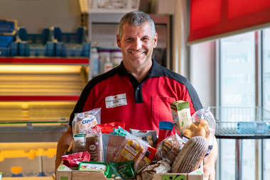 Mitarbeiter der Tafel mit Lebensmittelspenden in der Hand