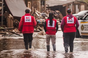 Rotkreuz Helferinnen gehen durch überflutete Straße in Brasilien