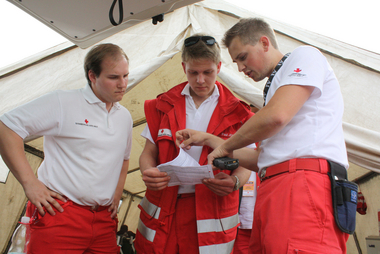 Mitarbeiter des Roten Kreuzes besprechen sich gerade vor Veranstaltungsbeginn über die Abwicklung des Ambulanzdienstes