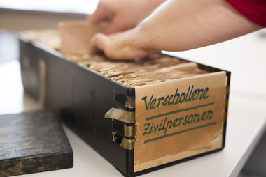 Nahaufnahme einer Box mit der Beschriftung "verschollene Zivilpersonen". Darin sind Karteikarten.