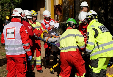 Ein Mann wird von Einsatzkräften auf einer Bahre rausgetragen.