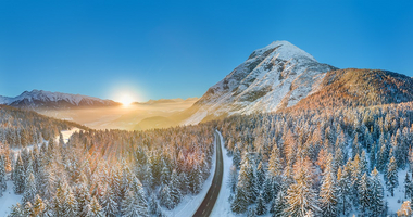 Am Bild zu sehen ist ein wunderschöner Sonnenuntergang in den Bergen im Winter