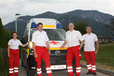 Vier Rettungssanitäter vor dem Rettungsauto