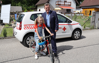 Cornelius Obonya mit Kind-Darstellerin vor Wagen des Mobilen Hospizes