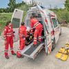 Drei Sanitäter sind am Notfallort eingetroffen und haben die verletzte Person in den Rettungswagen gebracht.