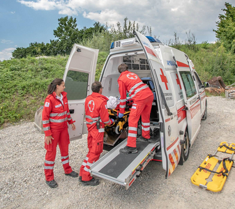 Drei Sanitäter sind am Notfallort eingetroffen und haben die verletzte Person in den Rettungswagen gebracht.