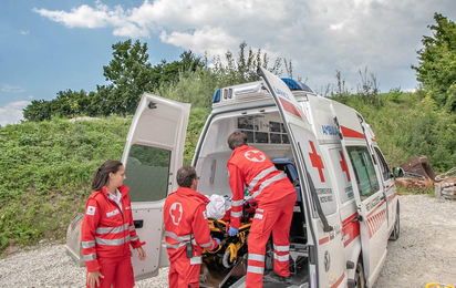 Drei Sanitäter sind am Notfallort eingetroffen und haben die verletzte Person in den Rettungswagen gebracht.