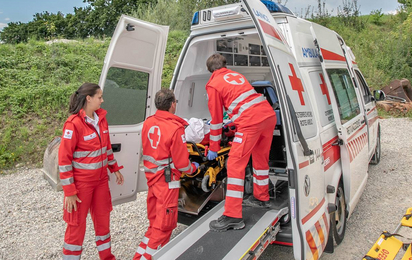 Drei Sanitäter sind am Notfallort eingetroffen und haben die verletzte Person in den Rettungswagen gebracht.