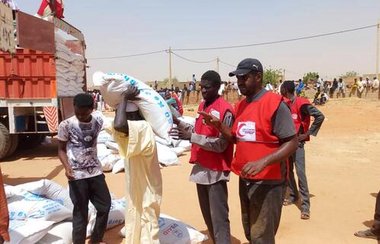 Mitarbeiter des Roten Halbmonds helfen im Sudan und verteilen Säcke mit Nahrung.