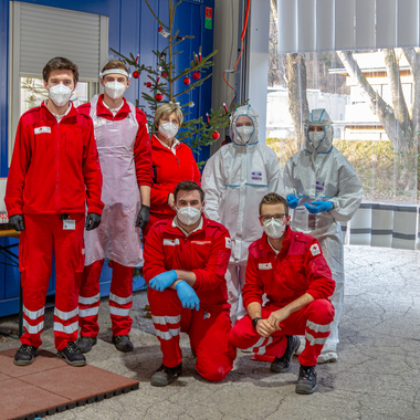 Screening Team in Schutzausrüstung vor dem Christbaum in der Screeningstraße