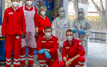 Screening Team in Schutzausrüstung vor dem Christbaum in der Screeningstraße