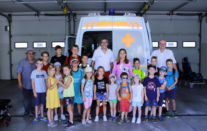 Gemeinsames Gruppenfoto mit den Kindern des Sollenauer Ferienspiels vor einem Rettungswagen