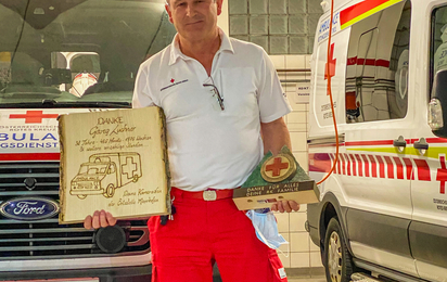 Georg Luchner mit den Geschenken der Ortsstelle Mayrhofen vor einem Rettungswagen