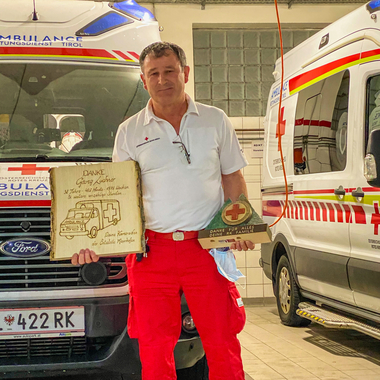 Georg Luchner mit den Geschenken der Ortsstelle Mayrhofen vor einem Rettungswagen