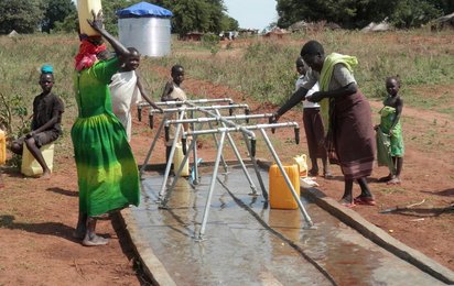 Menschen an einem Wasserbrunnen in Uganda