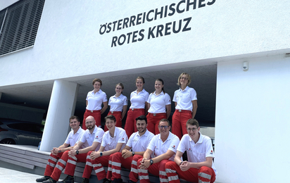 Elf Rettungssanitäter in Uniform stehen und sitzen in zwei Reihen