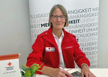 Gesundheits- und Sozialbegleiterin Bernardine Heckman sitzt am Tisch mit einem Kugelschreiber in der Hand