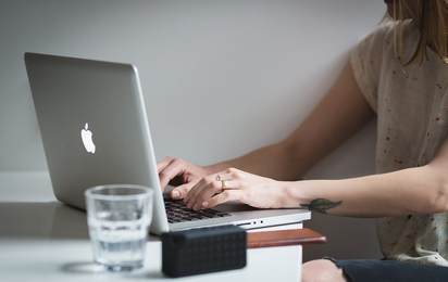 Eine Frau tippt in einen Laptop