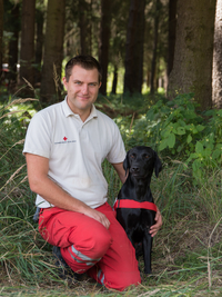 Hundeführer Andreas mit schwarzen Labradorrüden Aescu