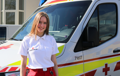 Felicia steht vor einem Rettungswagen.