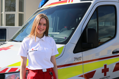 Felicia steht vor einem Rettungswagen.