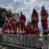 Ein Team an Rotkreuz-Sanitäter:innen steht auf und neben einem #AustrianGP-Schiftzug aus Beton am Formel 1 Grand Prix 2022 in Spielberg.