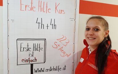 Mitarbeiter mit Plakat für Erste-Hilfe-Auffrischungskurs