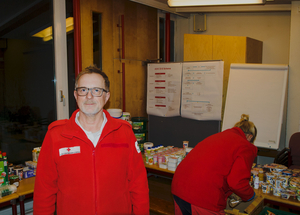 Michael Wutz - Leiter der Team Österreich Tafel - steht vor zu verteilenden Lebensmitteln. Im Hintergrund sortiert eine Mitarbeiterin gerade einige Lebensmittel.