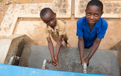 Zwei Kinder aus Ruanda waschen sich die Hände.