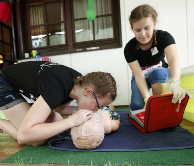 Im Bild zu sehen sind zwei Schüler, die bei einem Erste Hilfe Bewerb mitmachen und gerade einen Notfallcheck an einer Puppe vornehmen.  Bei inszenierten Unfällen und Verletzungen legten die 11- bis 19-jährigen Mädchen und Burschen Druckverbände an, versorgten Wunden und führten die Wiederbelebung durch.