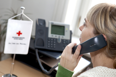 Eine Rotkreuz-Mitarbeiterin macht Dienst bei der Kummernummer und berät gerade am Telefon