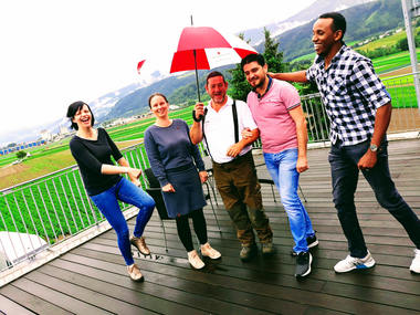 Fünf motivierte und fröhliche Mitarbeiterinnen des Roten Kreuzes Tirol auf der Terrasse des Landesverbandes strahlen in die Kamera