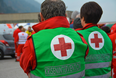 Zu sehen sind zwei Mitarbeiter des Kriseninterventionsteams von hinten. Sie beobachten ein Einsatzgeschehen. die Aufnahme stammt von einer Übung des Roten Kreuzes Tirol