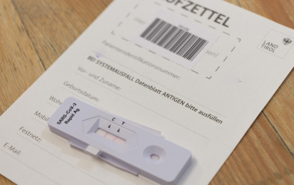 Antigen-Testkit mit 2 angezeigten Strichen auf dem Laufzettel