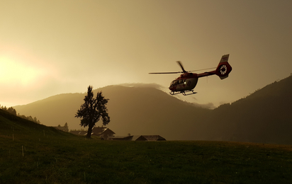 Der Rettungshubschrauber RK1 fliegt im Sonnenuntergang nach Hause.