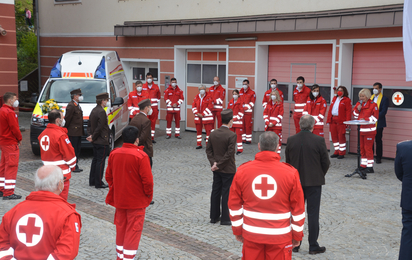 Mitarbeiter und Gäste stehen bei der Ortsstellenversammlung