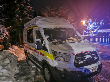 Rettungstransportwagen mit Schnee bei Nacht