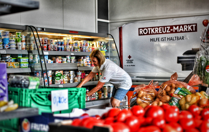 Mitarbeiterin räumt im Rotkreuz-Markt Waren ins Kühlregal