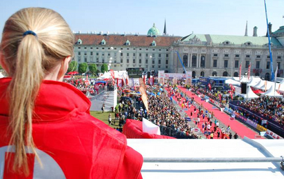 Vienna City Marathon: Eine Rotkreuz-Mitarbeiterin blickt auf die Menschenmasse beim Zieleinlauf des Marathons. Sie sorgt für Sicherheit.