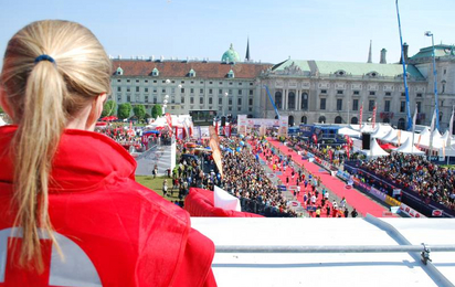 Vienna City Marathon: Eine Rotkreuz-Mitarbeiterin blickt auf die Menschenmasse beim Zieleinlauf des Marathons. Sie sorgt für Sicherheit.