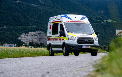 Am Bild zu sehen ist ein aktuelles Modell eines Krankentransportwagens des Rettungsdienstes auf einer Wiesenstraße