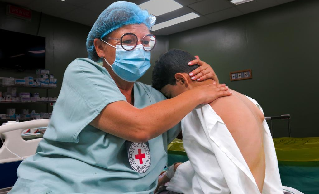 Ein Kind in Gaza wird von einer Mitarbeiterin des IKRK behandelt