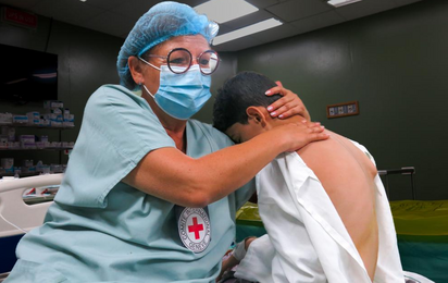 Ein Kind in Gaza wird von einer Mitarbeiterin des IKRK behandelt